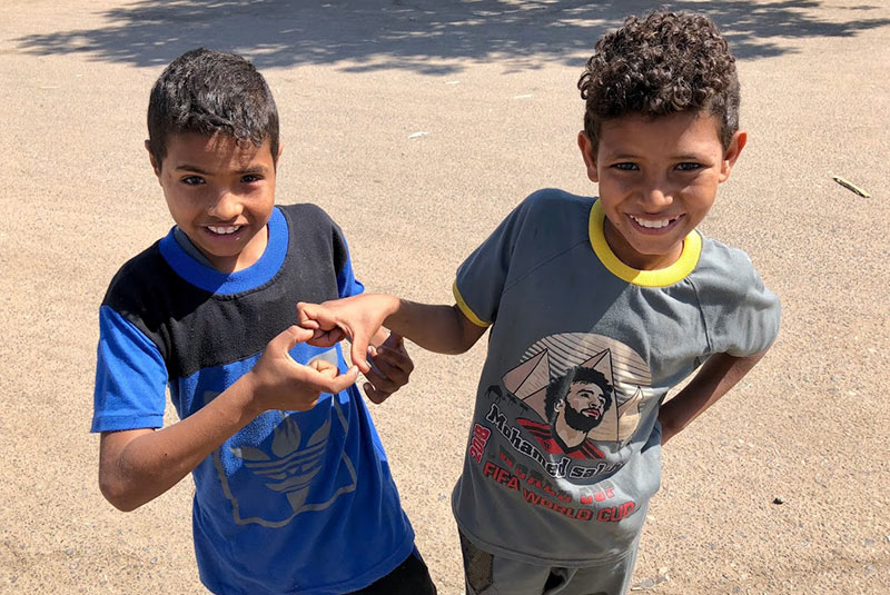 Two kids in Edfu make the shape of a heart with their fingers, Egypt
