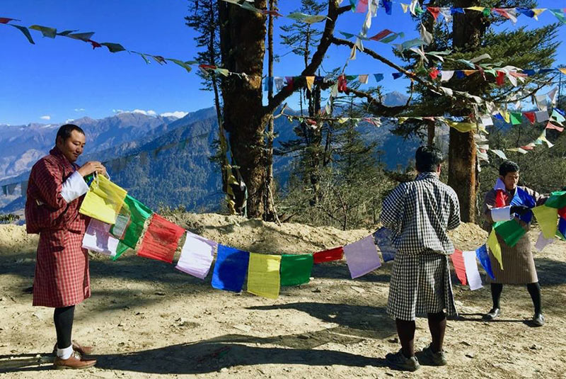 Hanging prayer flags on a mountain pass in Bhutan