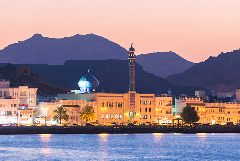 Muttrah Harbor and Old Town at dusk in Muscat, Oman