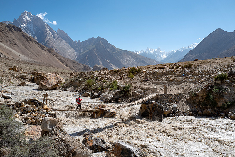 Trekker crossing a bridge en route to K2 and Broad Peak Base Camp, Pakistan