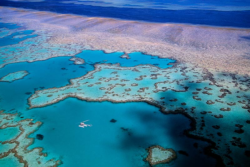 A small plane flies over Australia's Great Barrier Reef